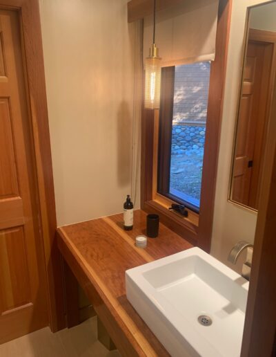 Modern bathroom interior with wooden cabinets and a white countertop sink.